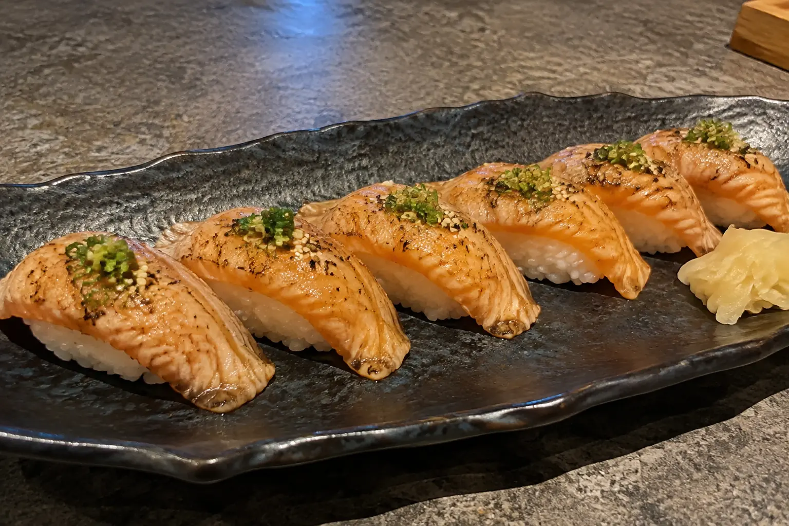 Flame seared salmon aburi nigiri with spring onion and sesame - Illustrative Image Flame seared salmon aburi nigiri with spring onion and sesame - Illustrative Image