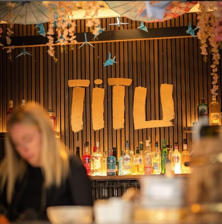Bartender at the Titu back bar beneath the origami cranes