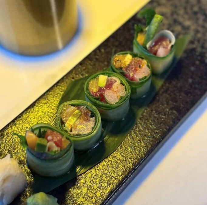 Cucumber wrapped sushi rolls served on slate at Titu