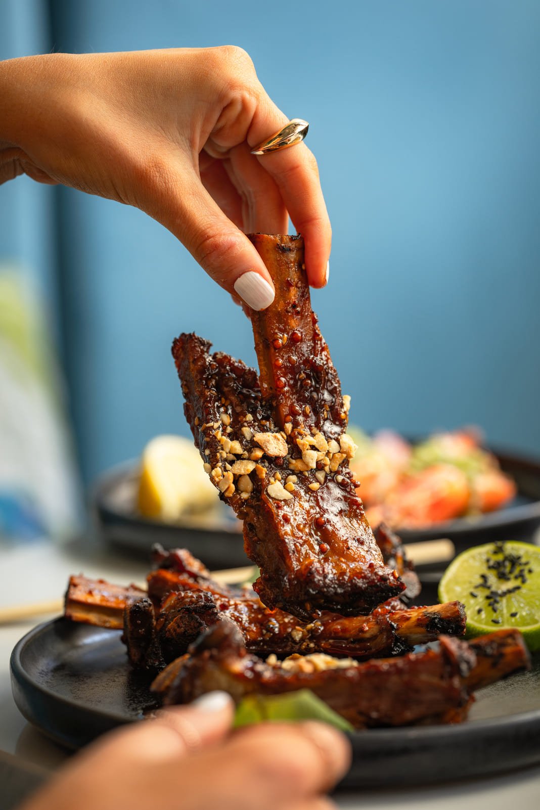 Diner lifting miso lamb ribs at Japanese fusion restaurant Mayfair