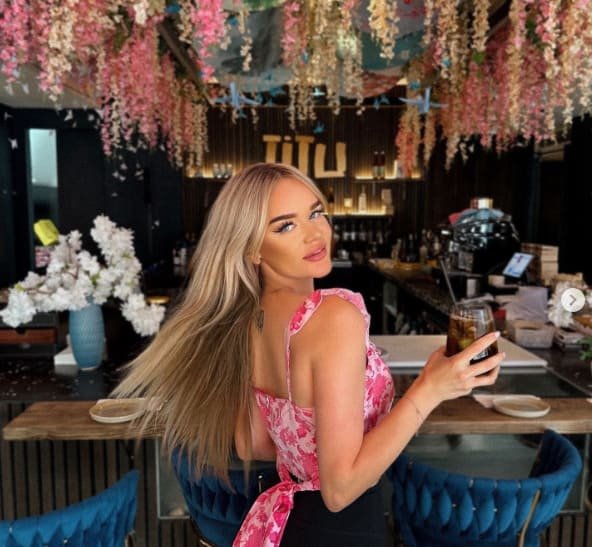 Guest with cocktail under blossom ceiling at Titu Japanese fusion restaurant London