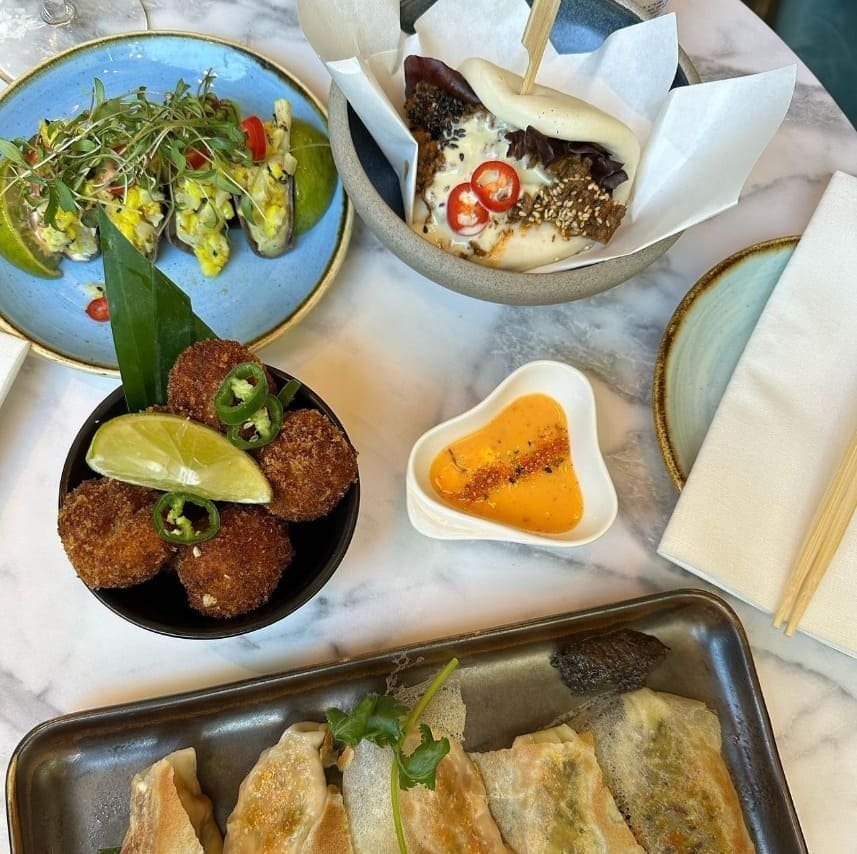 Gyoza, tacos and small plates laid out as a sharing spread