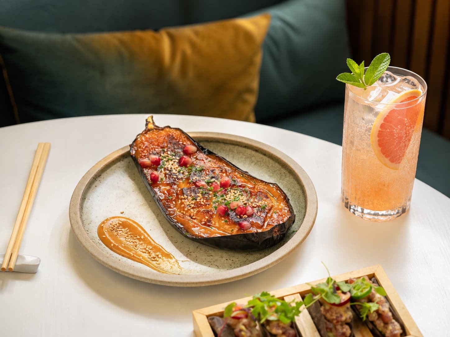 Miso-glazed aubergine with pomegranate and sesame, served with tacos