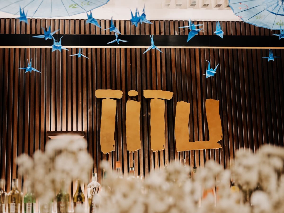 Titu signage on a slatted wall with blossom, Japanese fusion restaurant, Mayfair