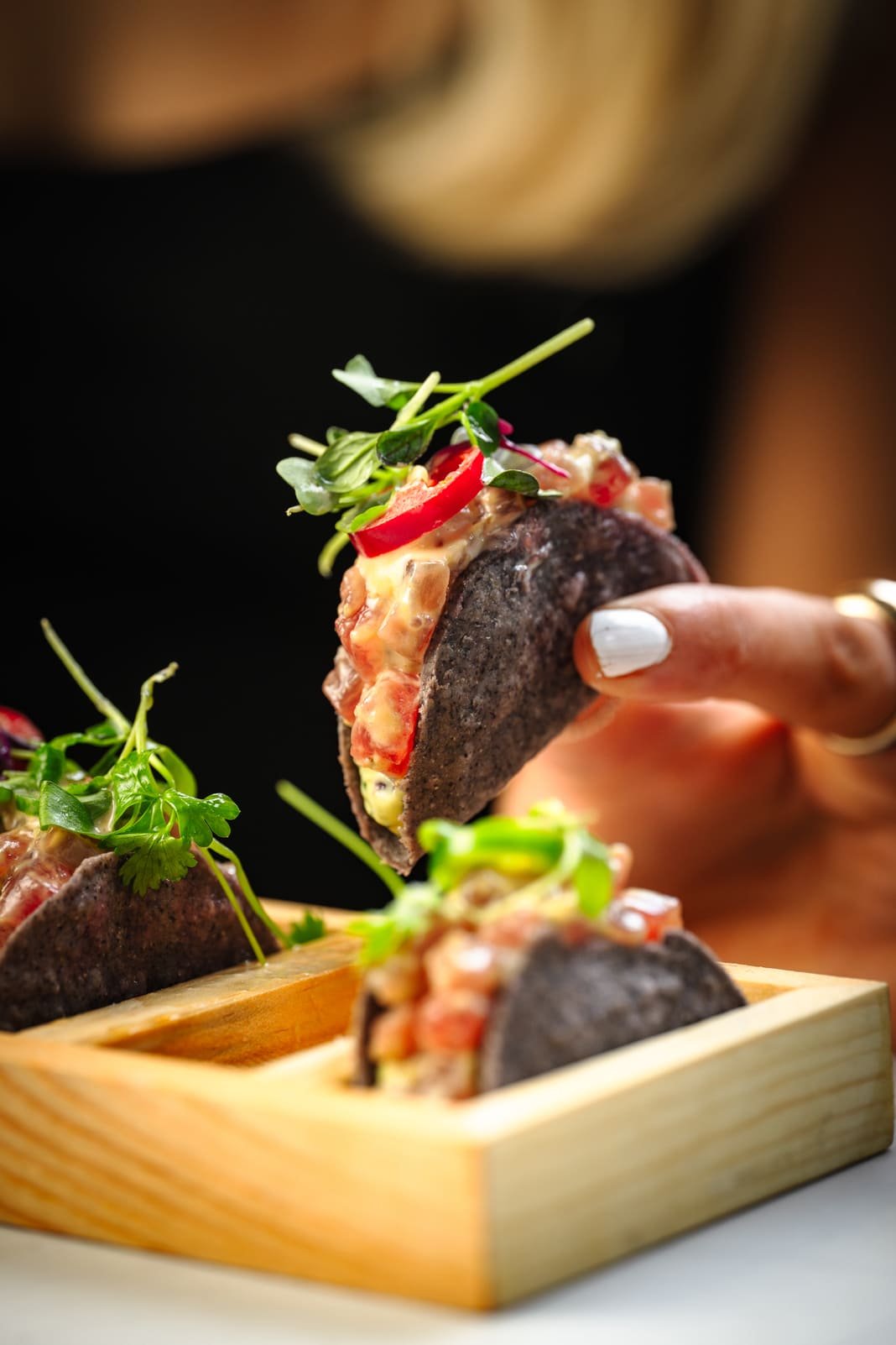 Wagyu taco held above wooden board, Asian fusion dining Mayfair